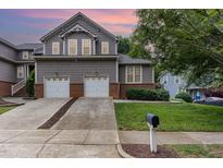 Charming two-story home featuring a two-car garage, mature landscaping, and a well-maintained lawn at 11005 Louson Pl, Raleigh, NC 27614