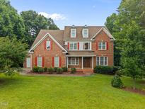 Charming brick two-story home with red shutters and a well-manicured lawn at 1124 Kalworth Rd, Wake Forest, NC 27587