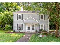 Charming duplex features a manicured lawn, and traditional architectural details and is shaded by mature trees at 118 Rhum Pl, Garner, NC 27529