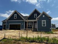Beautiful single-Gathering home showcasing its meticulous landscaping and inviting facade on a sunny day at 129 Retreat Run, Smithfield, NC 27577