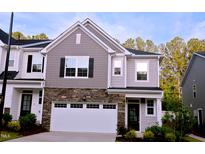 Charming two-story townhouse with stone accents, attached garage, gray shingles, and beautiful landscaping at 1441 Rosepine Dr Dr, Cary, NC 27519