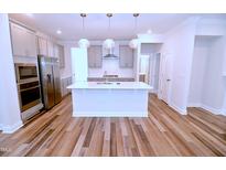 Modern kitchen features a spacious island, stainless steel appliances, and pendant lighting at 1441 Rosepine Dr Dr, Cary, NC 27519