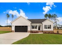 Charming, single-story home with a well-manicured lawn and a two-car garage at 162 Gumtop Dr, Zebulon, NC 27597