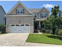 Charming two-story home with a brick front, manicured lawn, and a two-car garage at 1746 Hammocks Beach Trl, Apex, NC 27502