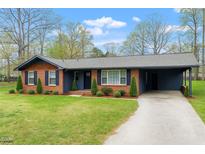Charming single-story brick house with a well-manicured lawn and an attached carport at 1813 Grady Dr., Durham, NC 27712