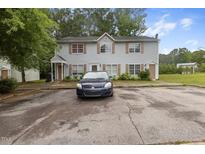Two-story home with light blue siding, brown shutters, and a spacious front parking area at 1824 Vintage Rd, Raleigh, NC 27610
