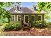 Charming, two-story home featuring dormer windows and a welcoming front porch surrounded by mature landscaping at 1869 Brevard Rd, Graham, NC 27253