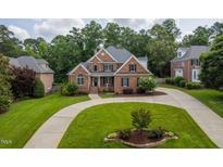 Beautiful two-story brick home with mature trees and a circular driveway at 209 Bailey Ridge Dr, Morrisville, NC 27560