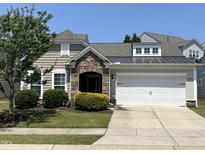 Charming one-story home featuring stone accents, a manicured lawn, and a two-car garage at 2535 Kinglass Dr, Fuquay Varina, NC 27526