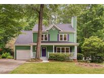 Charming two-story green home with a covered front porch and a well-manicured lawn at 2724 Glastonbury Rd, Apex, NC 27539