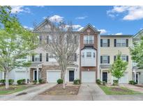 Charming townhomes boast diverse facades, attached garages, and landscaped front yards under a bright blue sky at 3027 Courtney Creek Blvd, Durham, NC 27713