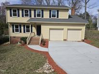 Charming two-story home featuring a well-manicured lawn, new driveway, and an attached two-car garage at 309 Wyatts Pond Lane, Cary, NC 27513
