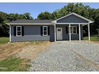 Charming home featuring gray siding, black shutters, and a welcoming front porch area at 311 W Market St, Graham, NC 27253