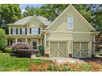 Charming two-story home with a well-manicured lawn and two-car garage, surrounded by lush greenery at 3124 Briar Stream Run, Raleigh, NC 27612