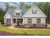 Charming home with a stone accent base, lush landscaping, and a cozy front porch at 40 Yellowstone Ct, Youngsville, NC 27596