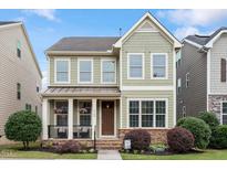 Charming two-story home featuring a welcoming front porch, well-maintained landscaping, and a mix of stone and siding accents at 4120 Overcup Oak Ln, Cary, NC 27519