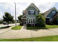 Charming two-story home featuring a welcoming front porch, well-kept lawn, and neat landscaping at 421 Old Ride Dr, Holly Springs, NC 27540