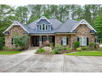 Stunning stone-clad home with beautiful landscaping, mature trees, and a classic architectural design at 4924 Stoneyoak Ln, Raleigh, NC 27610