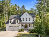 Charming two-story farmhouse-style home featuring a manicured front lawn and a welcoming front porch at 5034 Blendon Trl, Garner, NC 27529