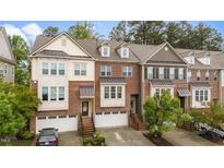 Charming brick townhome with attached garages, front stairs, and manicured landscaping at 5321 Cambridgeshire Loop, Cary, NC 27519