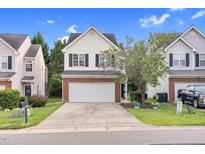 Charming townhouse with a two-car garage, brick accents, and well-maintained front yard at 5512 Grand Traverse Dr, Raleigh, NC 27604