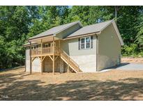 Inviting two-story home featuring a charming porch and situated on a spacious lot surrounded by lush trees at 5576 Foothills Ct, Snow Camp, NC 27349