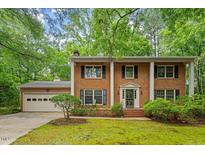 Charming brick home featuring a classic design, well-manicured lawn and mature trees at 604 Eden Ln, Chapel Hill, NC 27517