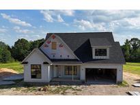 Charming new construction home with a modern white exterior, black windows and a two-car garage at 6332 River Rd, Fuquay Varina, NC 27526