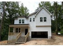New construction two-story home with white siding, a front porch, and an attached two-car garage at 701 Locust Ln, Raleigh, NC 27603