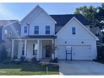 Beautiful two-story home featuring a white exterior, covered porch, and two-car garage at 750 Bachelor Gulch Way, Apex, NC 27523