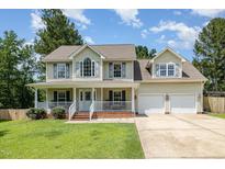 Charming two-story home with a welcoming front porch and well-manicured lawn at 105 Rolling Stone Ct, Sanford, NC 27332