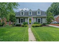 Charming home with dormer windows, a green door and lush landscaping at 1110 Edgewood Ave, Burlington, NC 27215