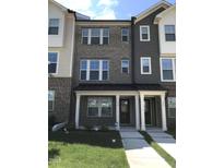 Townhouse exterior showcasing a brick facade, covered porch, and well-maintained landscaping at 115 Ballyliffen Ln, Cary, NC 27519