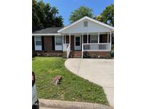 Charming brick home with a covered front porch, well-maintained lawn, and concrete driveway at 1210 Fayetteville St, Smithfield, NC 27577