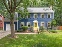 Charming two-story home with blue siding, gray shutters and a bright yellow front door at 1218 Chimney Hill Dr, Apex, NC 27502