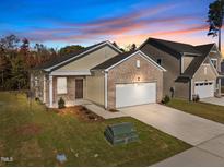 Charming single-Gathering home boasts a brick-accented facade and attached two-car garage at 1257 Pond Overlook Drive, Nashville, NC 27856