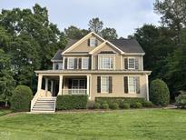 Charming two-story home featuring a covered front porch, black shutters, and a well-manicured lawn at 126 Riverglade Dr, Clayton, NC 27527