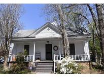 Charming white home featuring a welcoming front porch, traditional architecture, and inviting curb appeal at 1301 E Jones St, Raleigh, NC 27610