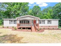 Charming single-story home boasts a welcoming front porch and well-maintained landscaping at 141 S Creek Dr, Louisburg, NC 27549