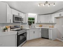 Modern kitchen featuring white cabinets, stainless steel appliances, and a bright, clean design at 141 S Creek Dr, Louisburg, NC 27549