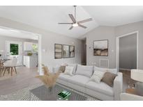 Bright living room with vaulted ceiling, modern fan, and neutral decor offers a comfortable and stylish space at 1941 White Memorial Church Rd, Willow Springs, NC 27592