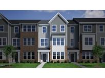 Charming townhome exterior with brick accents, neutral siding, and meticulously maintained landscaping at 375 Chesapeake Commons St # 117, Garner, NC 27529
