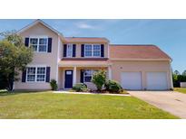 Charming two-story home features a two-car garage, complemented by lush greenery and vibrant landscaping at 417 Downing Glen Dr, Morrisville, NC 27560
