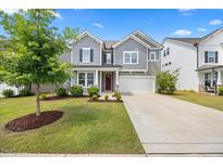 Charming two-story home with manicured lawn, gray siding, stone accents, and a two-car garage at 4508 Valley Crest Ln, Fuquay Varina, NC 27526