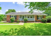 Charming brick ranch home with a cozy front porch and well-manicured lawn in a peaceful neighborhood at 5 Windsor Pl, Mebane, NC 27302