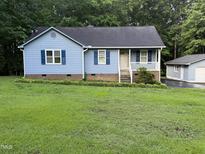 Charming single-Gathering home with light blue siding, dark shutters, and a manicured lawn at 535 Hillcrest Dr, Garner, NC 27529