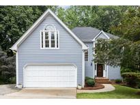 Charming home exterior with light blue siding, white garage door and trim, and manicured front yard at 7605 Sandy Lake Ct, Raleigh, NC 27613