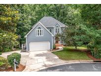 Charming two-story home with a two-car garage, mature trees, and a well-manicured lawn at 7605 Sandy Lake Ct, Raleigh, NC 27613