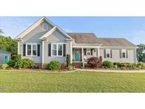 Charming single-story home featuring manicured lawn, gray siding, and a welcoming front porch at 817 Mossy Oak Dr, Fuquay Varina, NC 27526