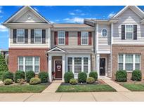 Charming townhome with manicured front lawn, inviting entrance, and appealing architectural details at 886 Cupola Dr, Raleigh, NC 27603